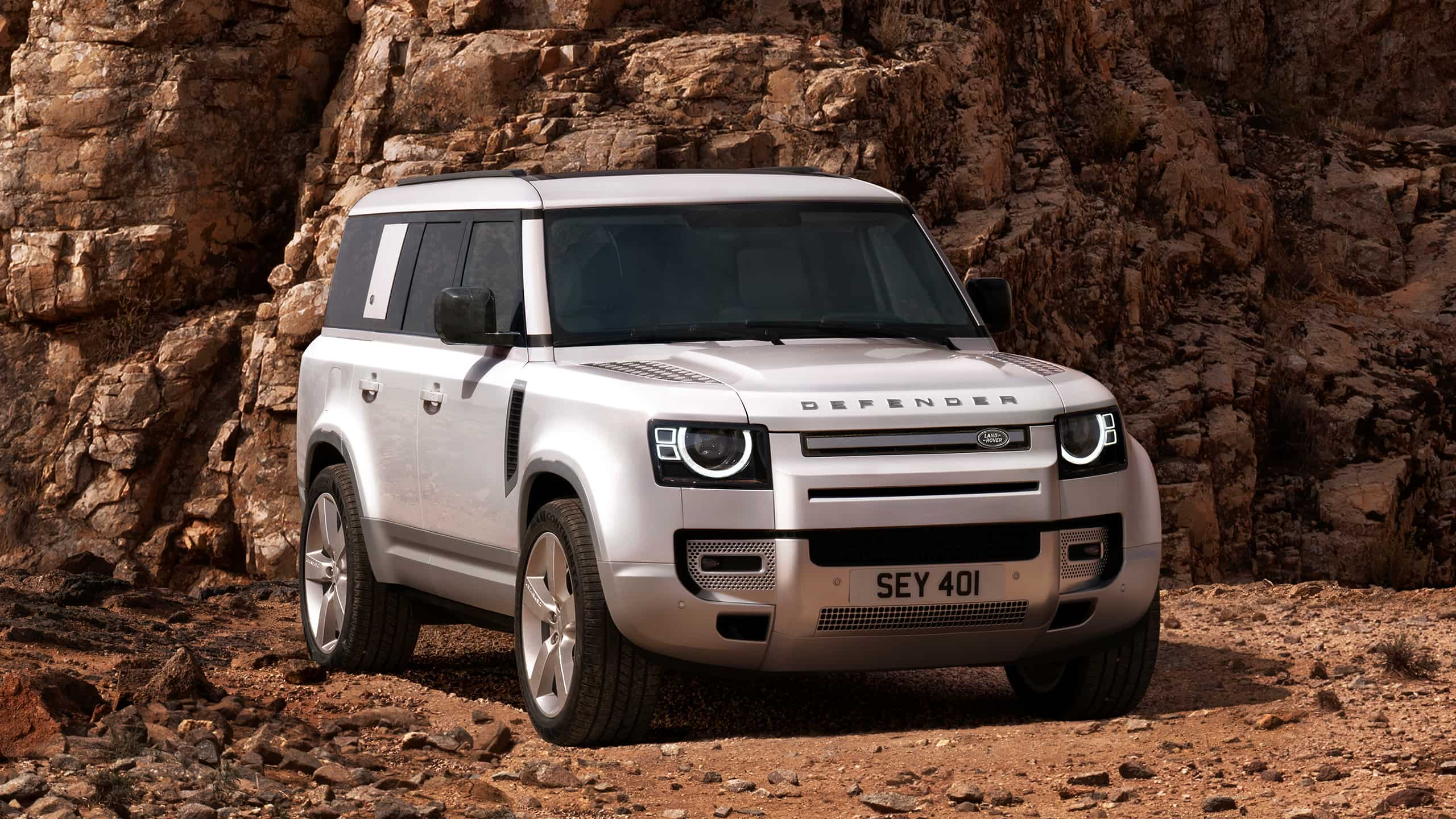 Defender Parked On Stone Road With A Mountain In Background