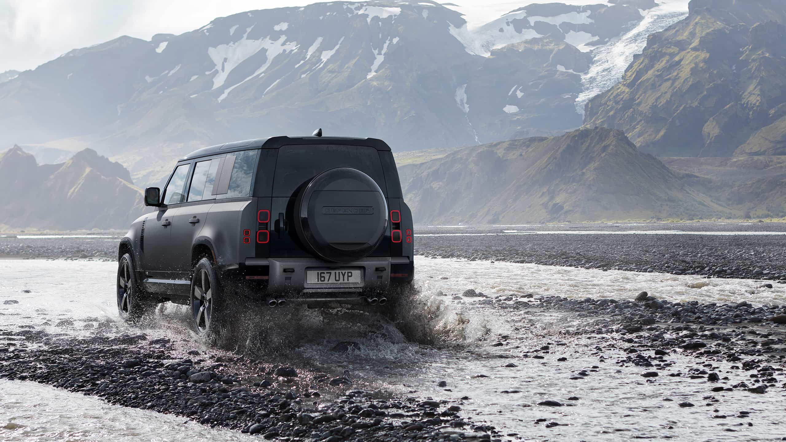 Defender is off roading in the mud of the river