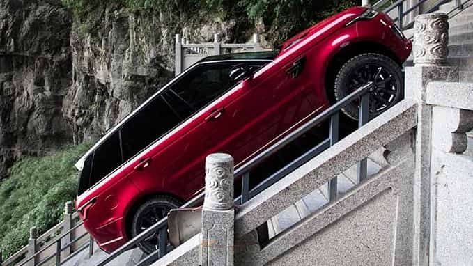 Red Range Rover driving up incline