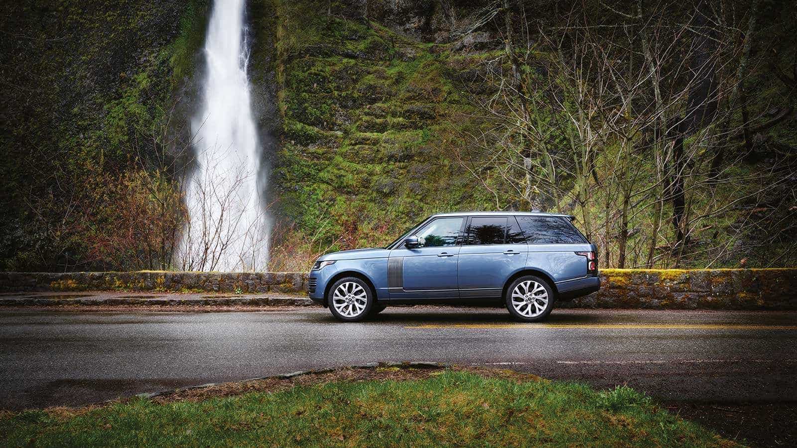 Range Rover HSE parked next to a waterfall