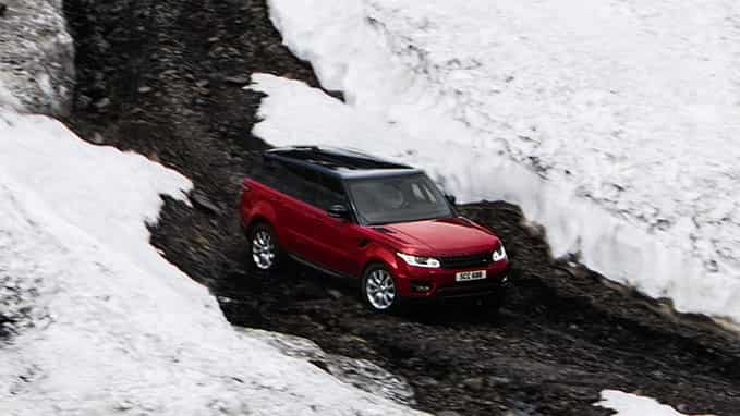 Red Range Rover driving through snow